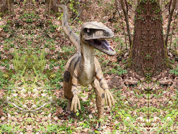 Une maquette de dinausaure au sein du parc Xploria, qui se situe juste à côté du terrain de camping 3 étoiles avec piscine Le Petit Pyrénéen en Ariège, dans les Pyrénées