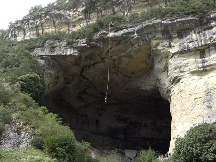 Vue sur l'entrée de la grotte du Mas-d'Azil où l'on aperçoit un élastique pendant qui a servi à pratiquer un saut à l'élastique à partir de la corniche de la grotte, à deux pas du terrain de camping 3 étoiles avec piscine Le Petit Pyrénéen en Ariège, dans les Pyrénées