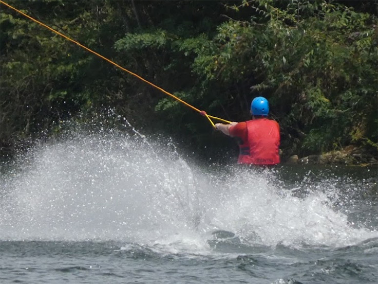 Un skieur nautique en téléski sur la base nautique de Mercus, non loin du terrain de camping 3 étoiles avec piscine Le Petit Pyrénéen en Ariège, dans les Pyrénées