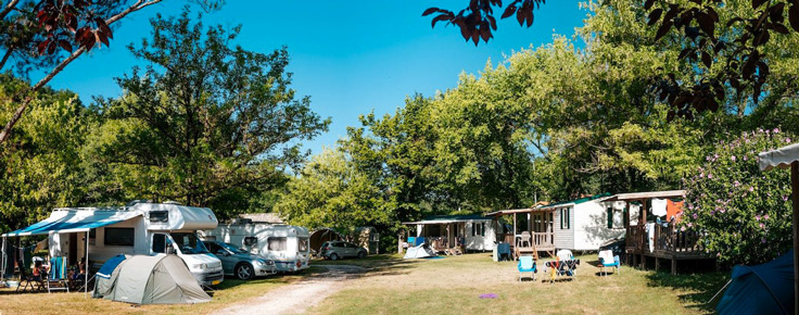 Vue de l'intérieur du terrain de camping 3 étoiles avec piscine Le Petit Pyrénéen, au Mas-d'Azil, en Ariège, dans les Pyrénées