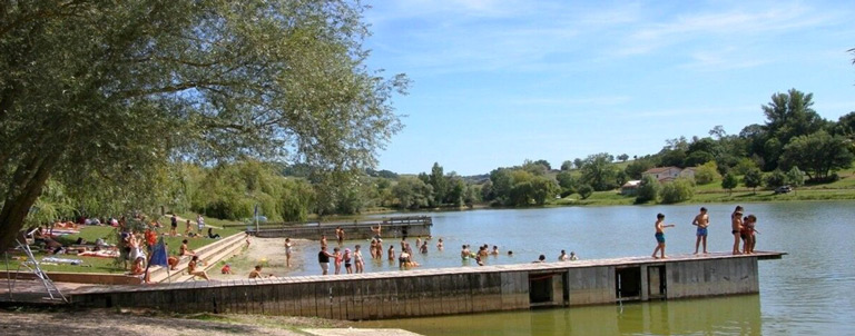 Le lac de Carla-Bayle en Ariège avec sa plage aménagée et la baignade surveillée, proche du terrain de camping 3 étoiles Le Petit Pyrénéen dans les Pyrénées