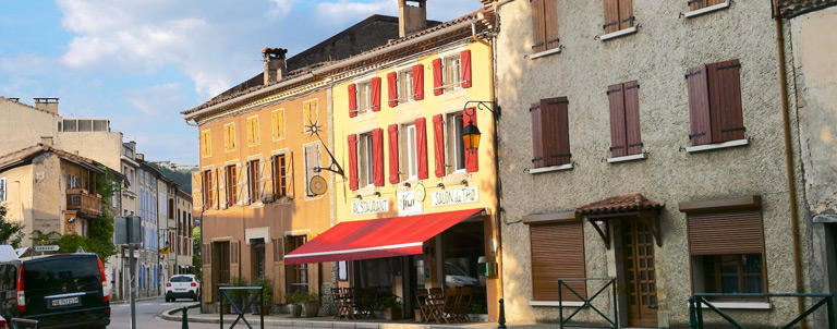 Vue sur une rue du village du Mas-d'Azil en Ariège dans les Pyrénées, avec en face, le restaurant Le Kiwi